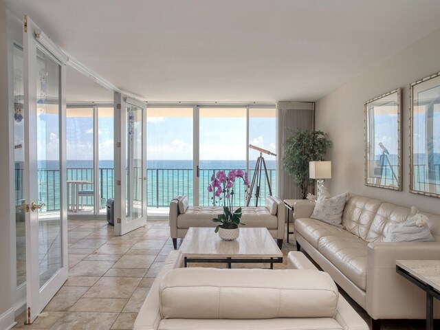 living room featuring a healthy amount of sunlight, a water view, and floor to ceiling windows