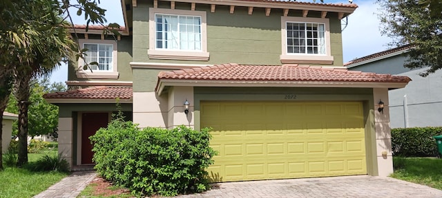 mediterranean / spanish home featuring a garage