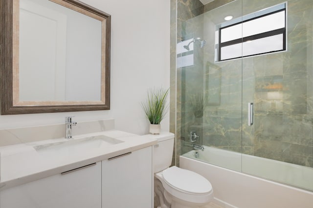 full bathroom with vanity, bath / shower combo with glass door, and toilet