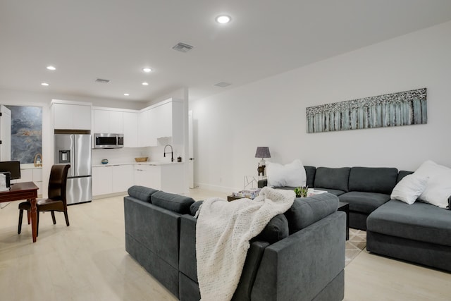 living room with sink and light hardwood / wood-style floors