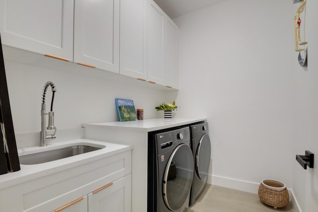 laundry room with cabinets, independent washer and dryer, sink, and light hardwood / wood-style flooring