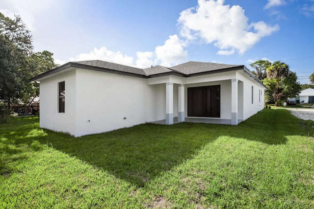 rear view of house featuring a lawn