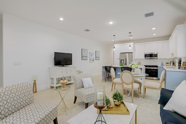 living room with light hardwood / wood-style floors and sink