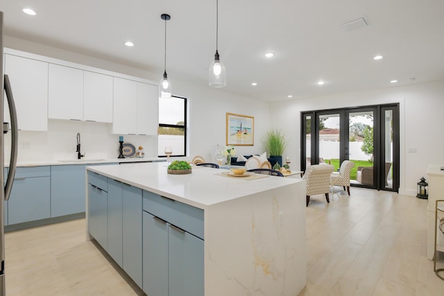 kitchen with pendant lighting, sink, a wealth of natural light, and a kitchen island