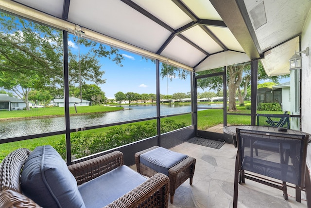 sunroom / solarium featuring a water view and vaulted ceiling