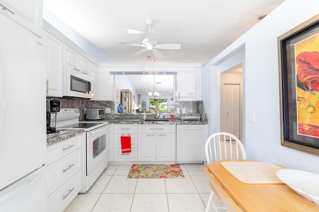 kitchen with stone counters, white cabinetry, hanging light fixtures, light tile patterned floors, and white appliances