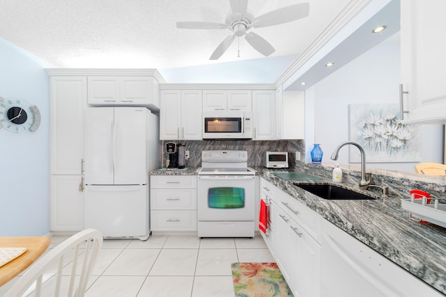 kitchen with lofted ceiling, white cabinetry, a textured ceiling, sink, and white appliances