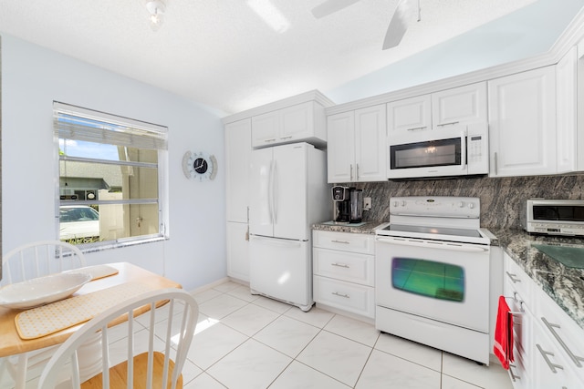 kitchen featuring backsplash, white cabinets, vaulted ceiling, and white appliances