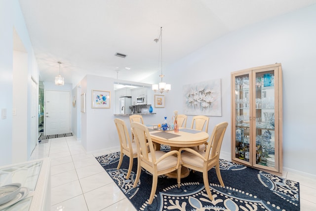 dining area featuring lofted ceiling, an inviting chandelier, and light tile patterned floors