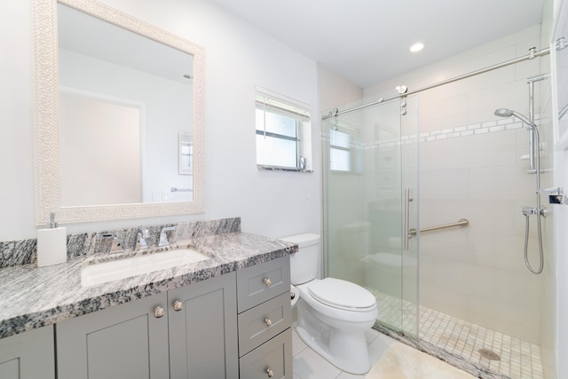 bathroom featuring tile patterned floors, vanity, toilet, and a shower with shower door