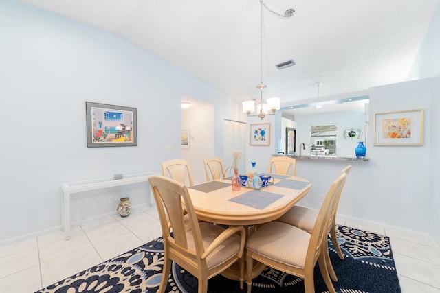 tiled dining room featuring a chandelier and vaulted ceiling