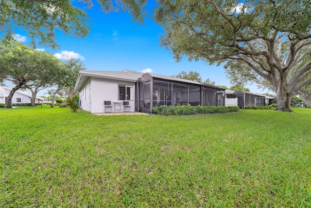 rear view of property with a sunroom and a yard