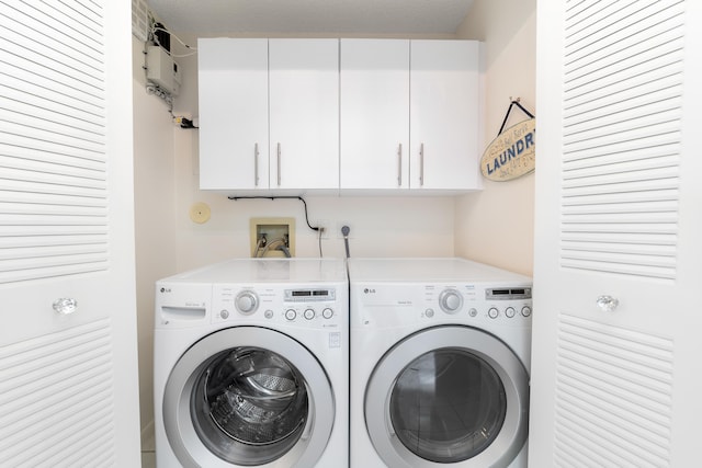 washroom featuring cabinets, washer and dryer, and a textured ceiling