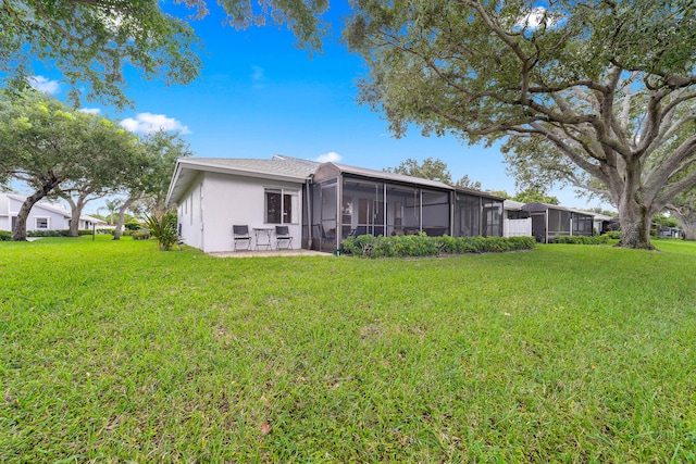 back of house with a patio, a lawn, and a sunroom