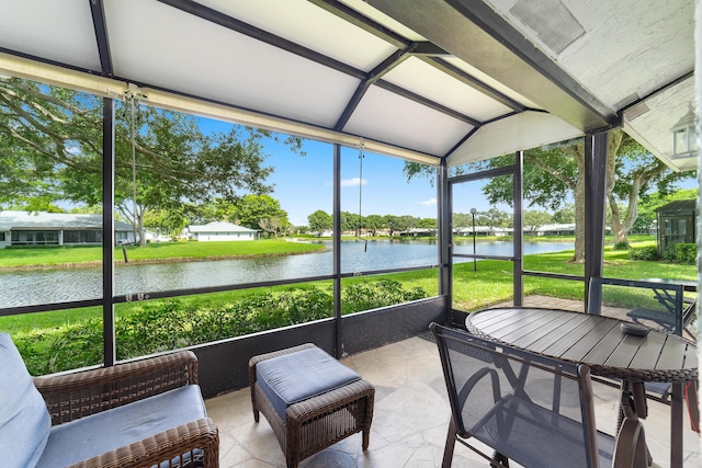 sunroom featuring a water view and vaulted ceiling