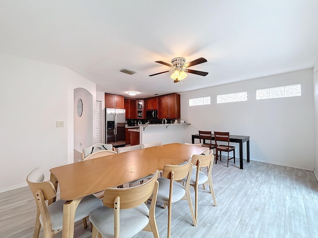 dining area with light wood-type flooring, sink, and ceiling fan