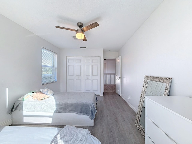 bedroom with hardwood / wood-style floors, ceiling fan, and a closet