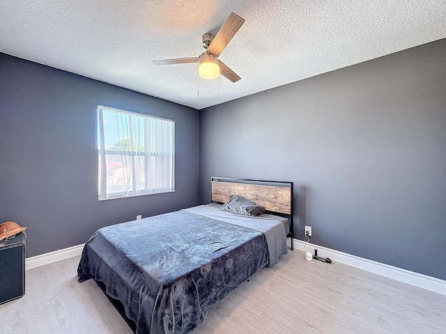 bedroom with pool table, light hardwood / wood-style flooring, a textured ceiling, and ceiling fan