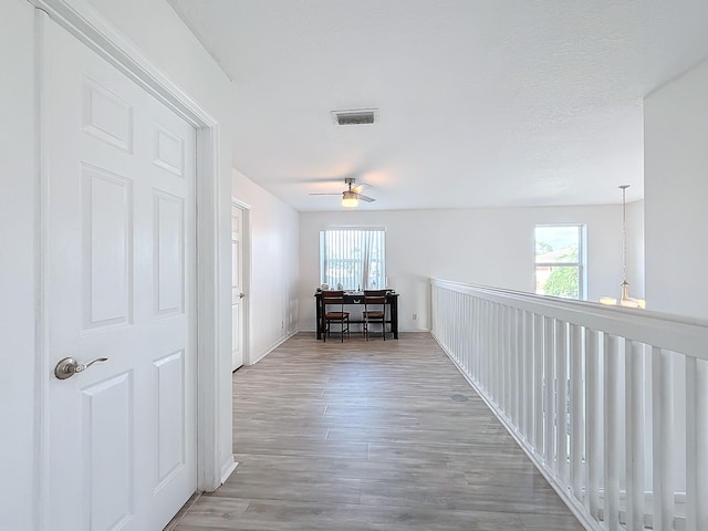 hallway featuring a chandelier, a textured ceiling, and hardwood / wood-style flooring