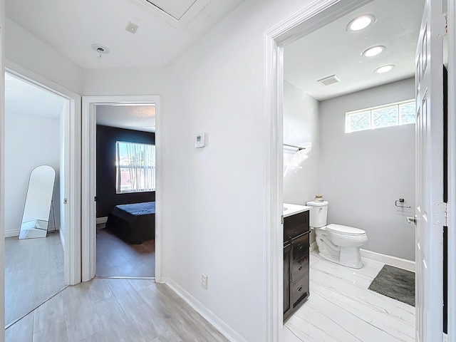 bathroom featuring toilet, vanity, a wealth of natural light, and hardwood / wood-style floors