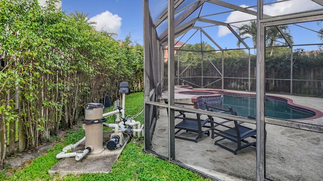 view of pool with a hot tub, glass enclosure, and a patio area