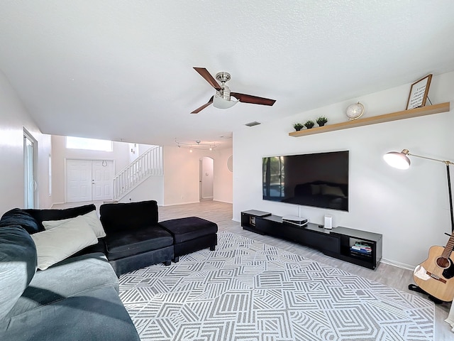 living room with light hardwood / wood-style flooring and ceiling fan