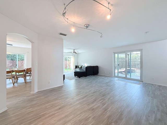 living room with ceiling fan, a healthy amount of sunlight, and light hardwood / wood-style flooring