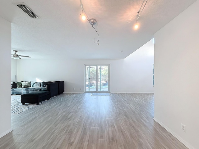 living room with rail lighting, a textured ceiling, ceiling fan, and light hardwood / wood-style flooring