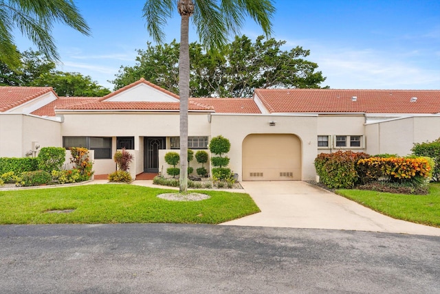 mediterranean / spanish home with a garage and a front lawn