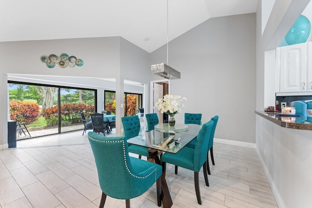 dining space with high vaulted ceiling