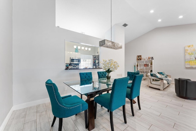 dining space with vaulted ceiling and light wood-type flooring