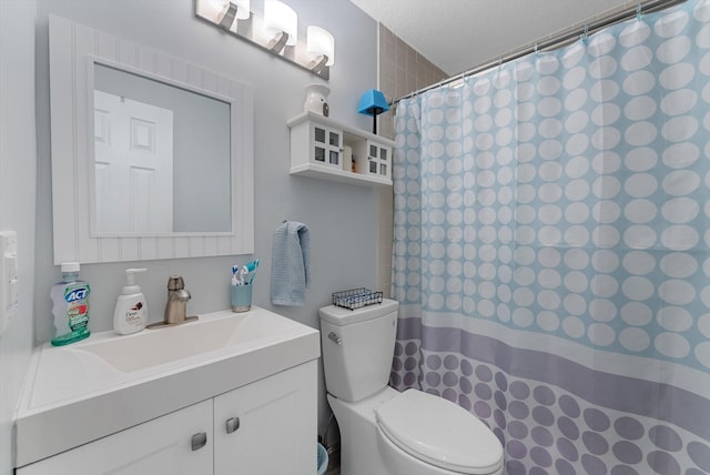 bathroom featuring vanity, toilet, walk in shower, and a textured ceiling