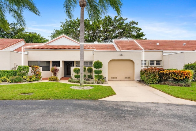 mediterranean / spanish home with a front lawn and a garage