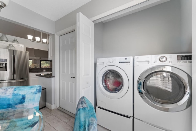 clothes washing area with washer and clothes dryer