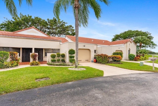 mediterranean / spanish house with a front lawn and a garage