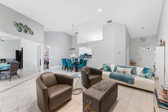 living room featuring light hardwood / wood-style floors, high vaulted ceiling, and ceiling fan with notable chandelier