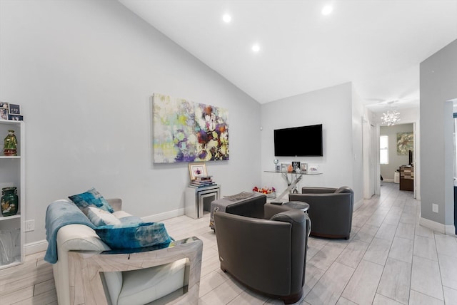 living room with light hardwood / wood-style floors, lofted ceiling, and an inviting chandelier