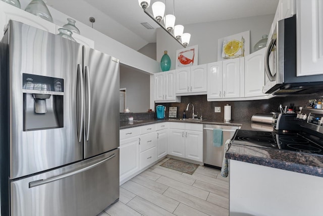 kitchen featuring sink, white cabinets, pendant lighting, appliances with stainless steel finishes, and tasteful backsplash