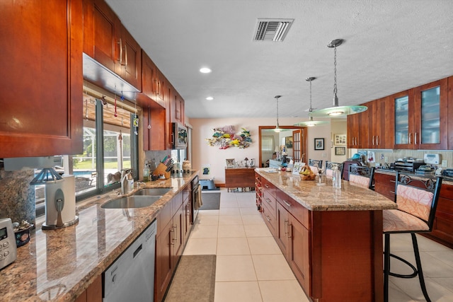 5609 SE Lamay Dr, Stuart, FL 34997 - kitchen with dishwasher, a kitchen island, a sink, a kitchen bar, and tasteful backsplash