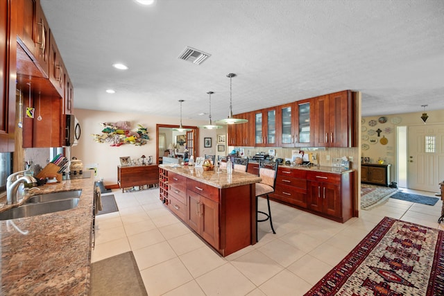 5609 SE Lamay Dr, Stuart, FL 34997 - kitchen with a sink, stainless steel microwave, a kitchen bar, glass insert cabinets, and recessed lighting