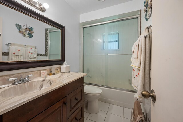 5609 SE Lamay Dr, Stuart, FL 34997 - full bath with vanity, toilet, tile patterned floors, and shower / bath combination with glass door
