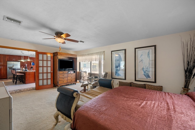 bedroom featuring stainless steel fridge, a textured ceiling, light colored carpet, and ceiling fan