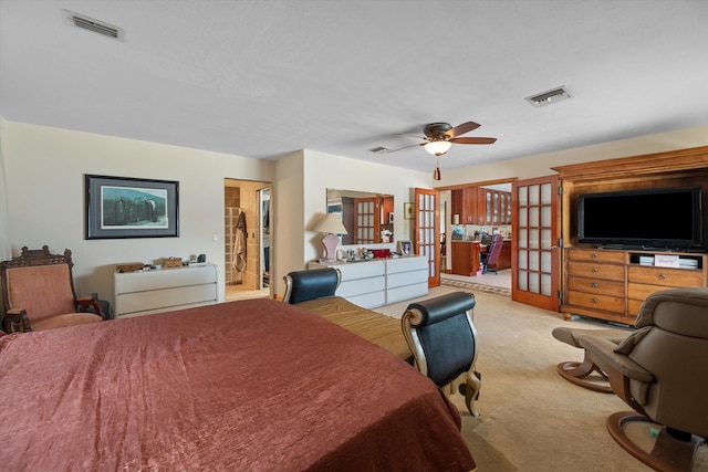 bedroom featuring light carpet, french doors, ensuite bathroom, and ceiling fan