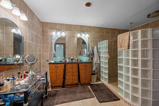 bathroom featuring vanity, tile patterned floors, a shower, and tile walls