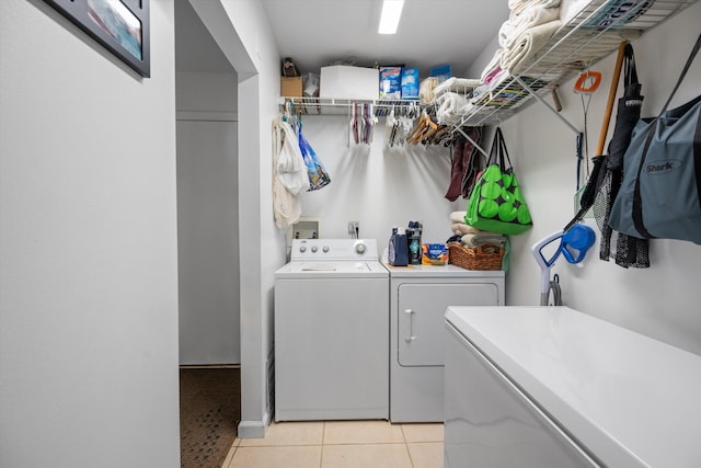 laundry room featuring washing machine and clothes dryer and light tile patterned floors