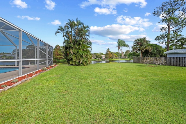 view of yard featuring a lanai and a water view