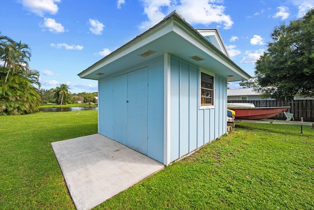 view of outbuilding with a yard and a water view