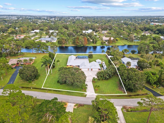 5609 SE Lamay Dr, Stuart, FL 34997 - aerial overview of property's location with a nearby body of water, property boundaries highlighted, nearby suburban area, and a tree filled landscape