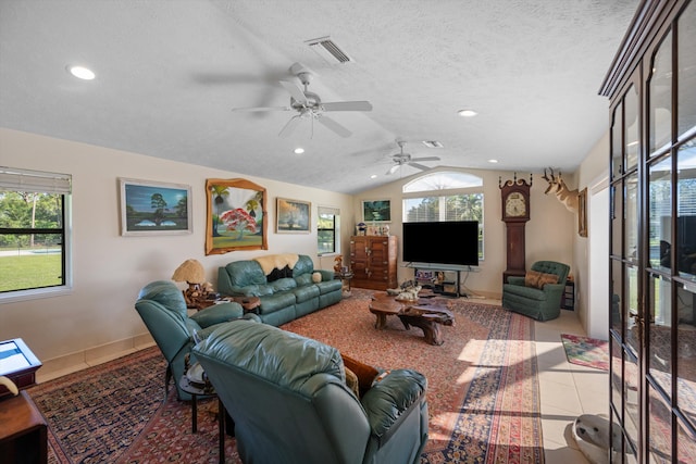 living room with lofted ceiling, a textured ceiling, light tile patterned floors, and ceiling fan