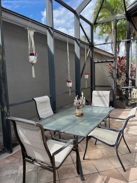 view of patio featuring glass enclosure